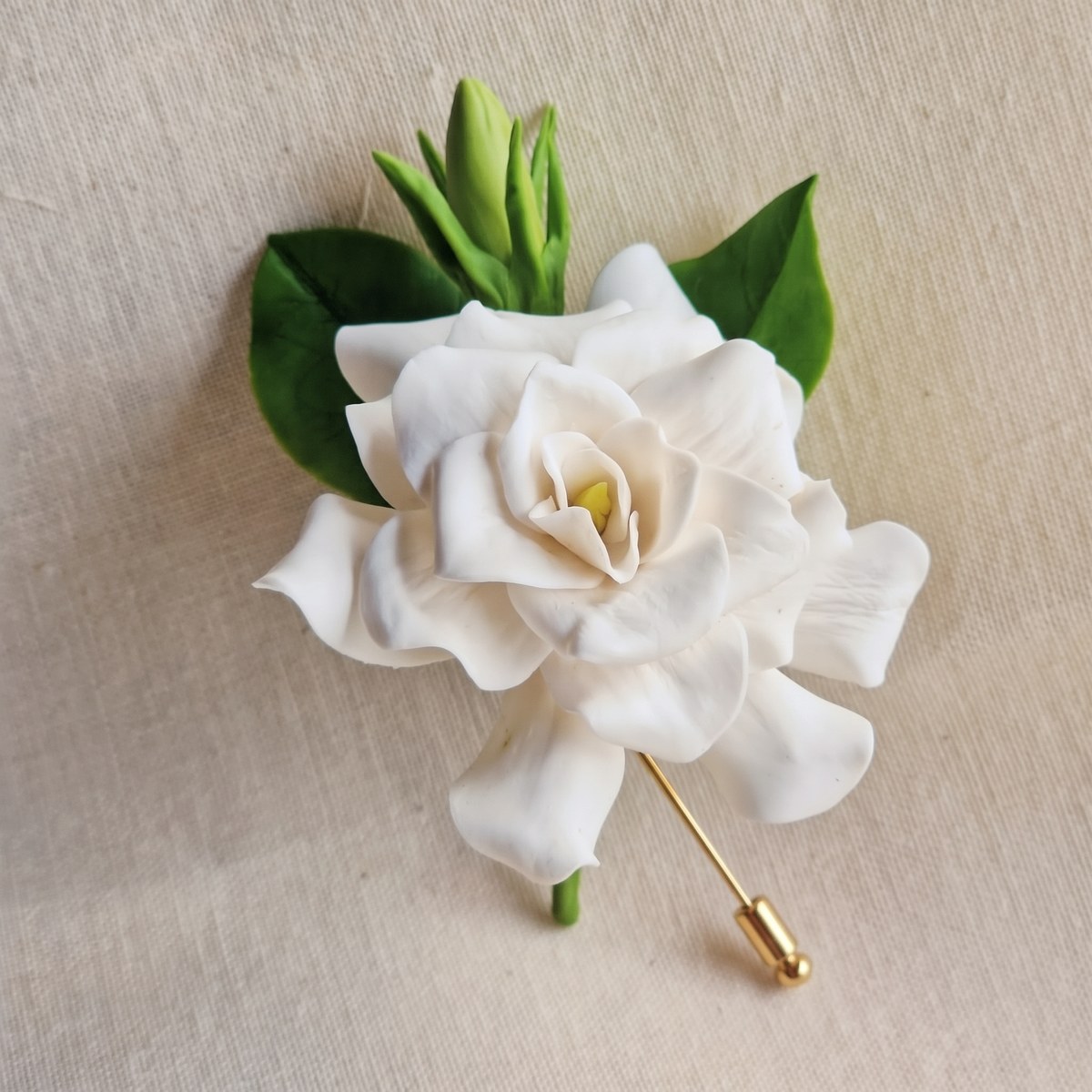 Ivory White cold porcelain gardenia lapel pin with green leaves and buds on a gold stick pin