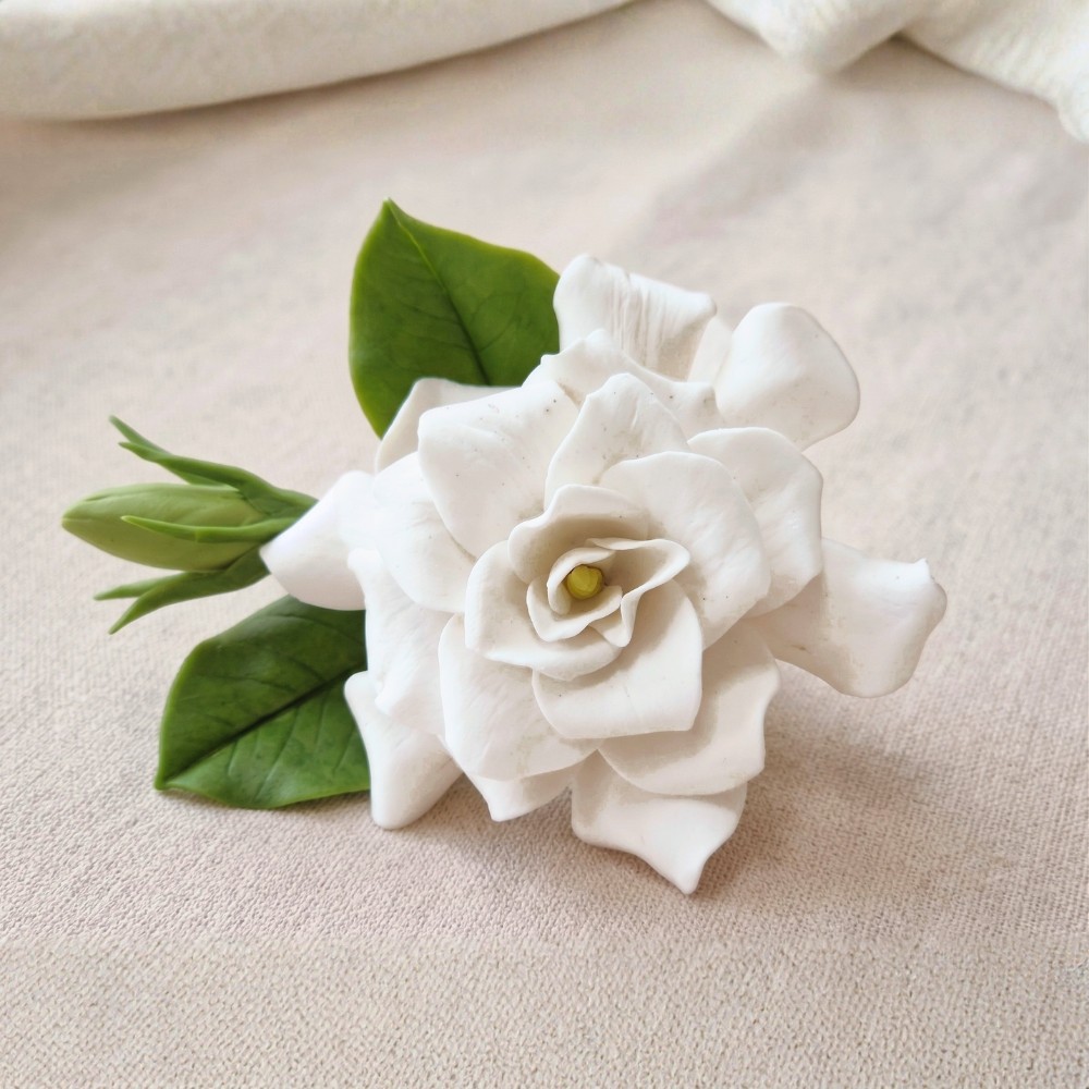 Hand-sculpted ivory white cold porcelain gardenia with green leaves