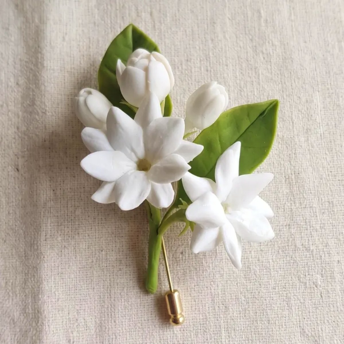 Ivory White cold porcelain jasmine lapel pin with buds and leaves on a gold stick pin