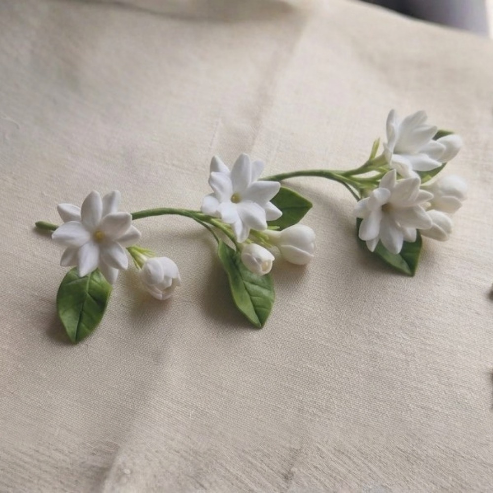 Three hand-sculpted cold porcelain jasmine sprigs with buds and leaves