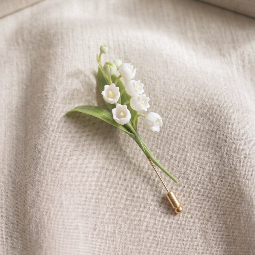 Ivory White cold porcelain lily of the valley spray with green leaves on a gold stick pin