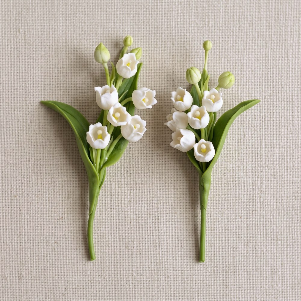 Two hand-sculpted Ivory White cold porcelain lily of the valley sprays with green leaves